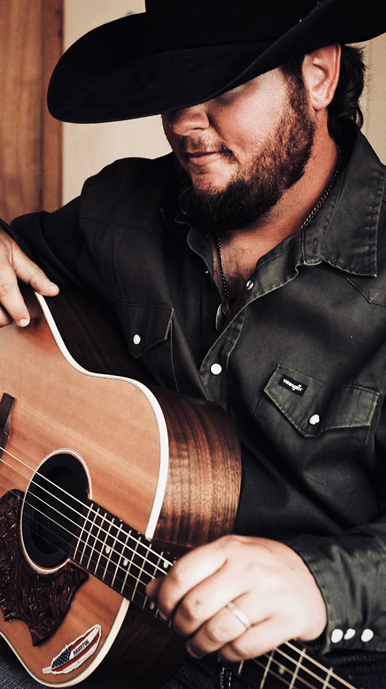 Ryan Talley, Texas country music singer-songwriter, performing live on stage with acoustic guitar. a professional country band for hire. Book Ryan Talley Music for events, weddings, and concerts.